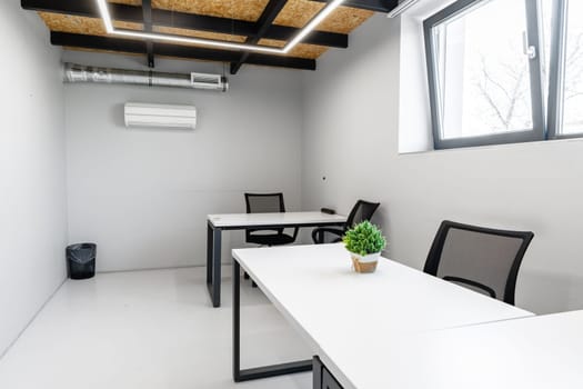 Bright office area featuring two desks and ergonomic chairs. The space has minimalist decor and effective lighting, perfect for productivity in a professional environment.