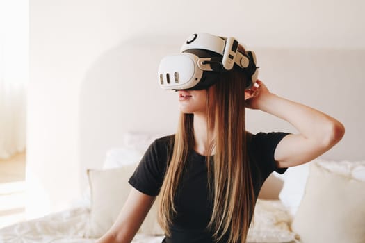 A young woman enjoys an interactive virtual reality experience, smiling as she adjusts the VR headset. Sunlight filters through the room, enhancing the relaxed atmosphere.
