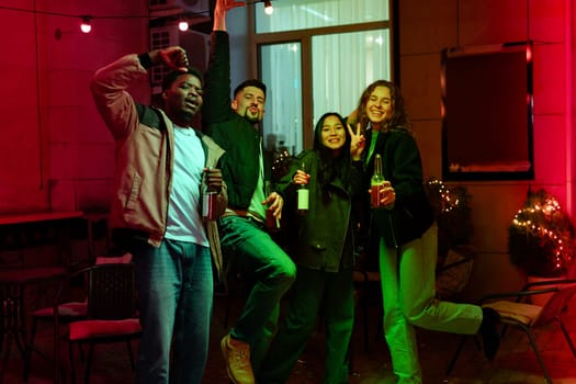 Groups of friends enjoy a lively evening gathering filled with laughter and drinks in a cozy outdoor space adorned with fairy lights, creating a festive atmosphere.