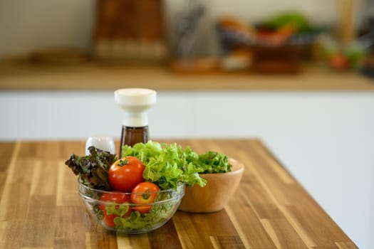 Fresh vegetable salad ingredients on wooden kitchen table.