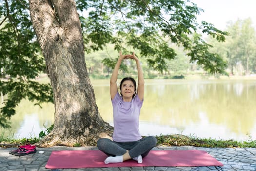 A woman engages in yoga and mindfulness exercises near a peaceful lake, promoting wellness and relaxation in nature.