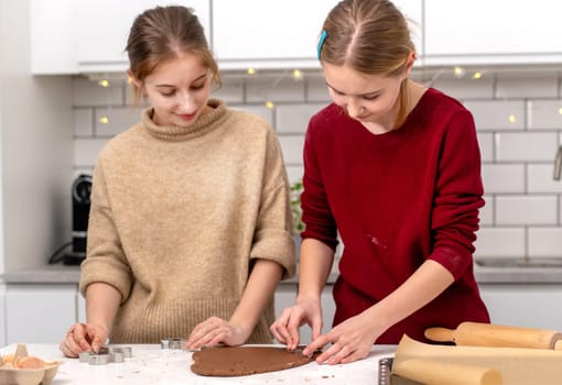 Teen Girls Making Gingerbread Cookies At Home In The Kitchen