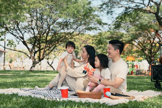 Cheerful family spending quality time, playing with bubble toys together in a sunny park.