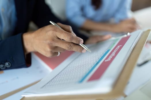 A businessman reviewing accounting sheets, emphasizing financial analysis and attention to detail in a corporate setting.