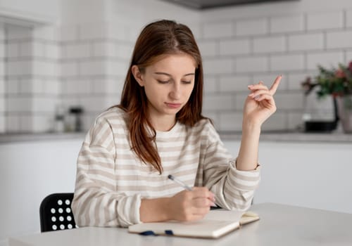 Girl Writing An Essay In A Notebook For Lyceum Preparation