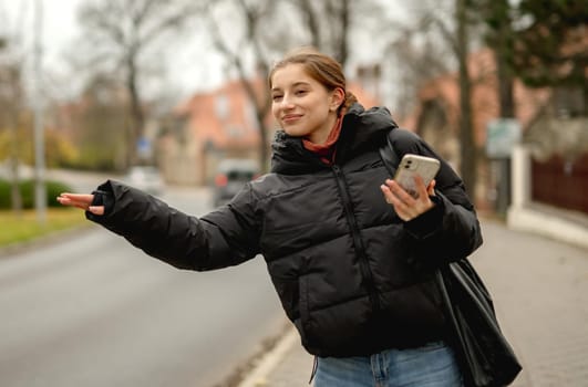 Cheerful Girl Trying To Stop Taxi Against The Backdrop Of The Street