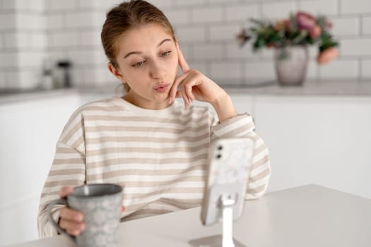 Unhappy Teen Girl Looking At Smartphone At Home