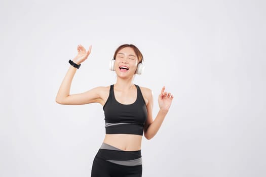 Dance becomes part of her daily fitness as she moves with rhythm and grace. Later, she hears a beat drop and starts to dance again with joyful determination. isolated studio white background