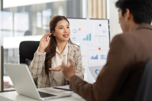 A young woman engages in a financial consultation, discussing strategies and insights with her colleague in a modern office.