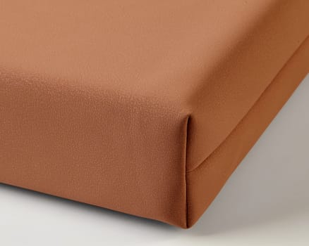 Close-up of light brown leather upholstery, highlighting the detailed stitching and textured surface