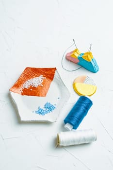 Process of creating jewelry with elements of beads and threads on the table
