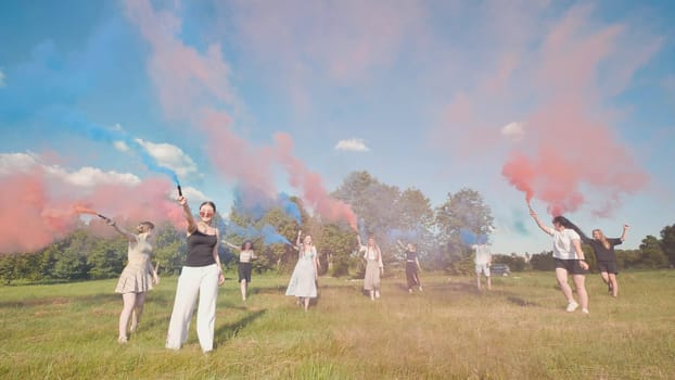 Group of teenagers celebrating in a sunny field, creating vibrant colored smoke during summer holidays, enjoying friendship and carefree fun