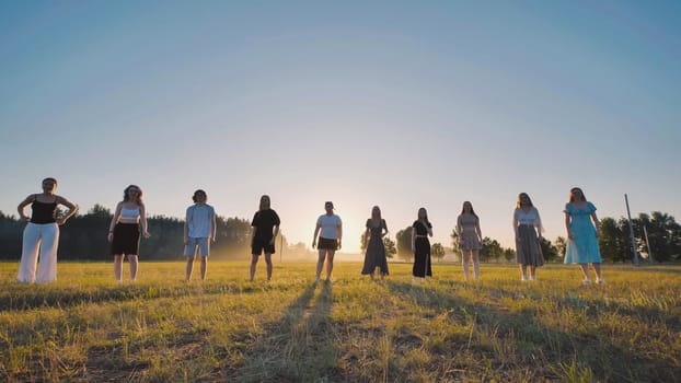 Students enjoying summer vacation, posing together in a field at sunset, capturing carefree moments of friendship and joy