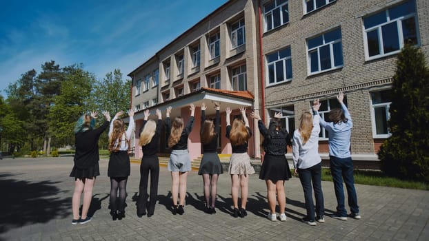 Happy students waving farewell to their school on the final day, marking the end of the school year with celebrations