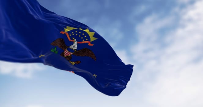 North Dakota state flag waving in the wind on a clear day. Blue with coat of arms. Eagle above North Dakota scroll. 3d illustration render. Selective focus. Fluttering textile