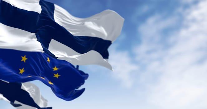 National flag of Finland waving in the wind with European Union flag on a clear day. 3d illustration render. Rippling fabric. Selective focus