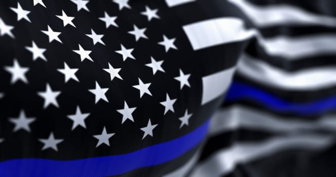 The flag of the United States of America in the Thin Blue Line variant waving in the wind. The Thin Blue Line flag is all black, bearing a single horizontal blue stripe across its center