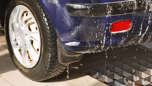 Soap dripping from the back of a car during an automatic car wash