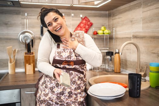 Woman talking on the phone while working in the kitchen.