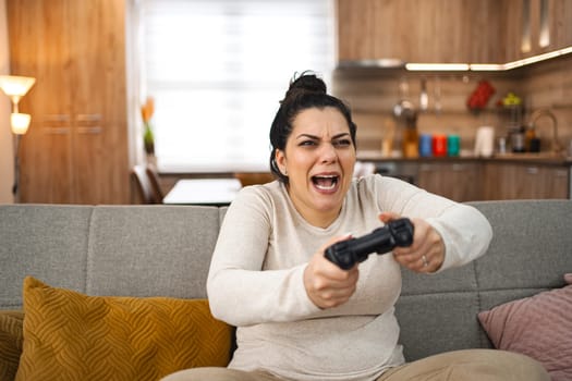 Competitive woman playing video game at home.