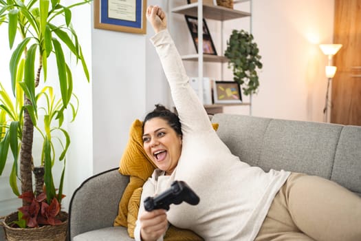 Woman having fun playing video games at home.