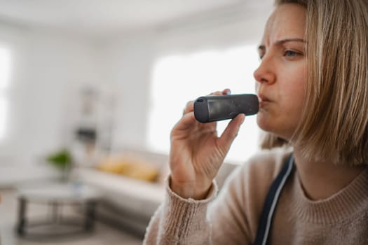 A woman intently engages with a health monitoring device at home.