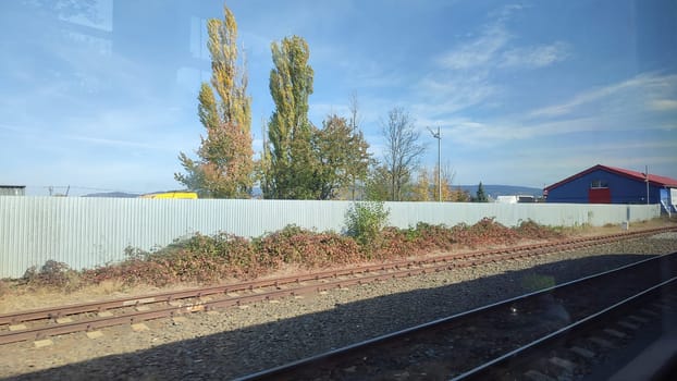 Train tracks foliage building architecture street trees shotlisttravel travel tourism summer day transport outdoor road nature landscape background blue sky . High quality photo
