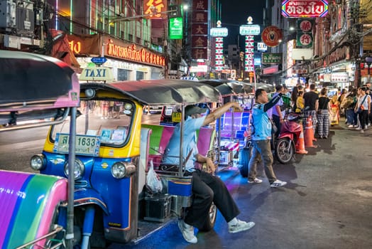 People and Tuk Tuk Taxi at Night Streetmarket on Yaowarat Road in Chinatown in City of Bangkok in Thailand.  Thailand, Bangkok, November, 4, 2024.
