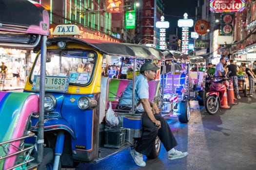 People and Tuk Tuk Taxi at Night Streetmarket on Yaowarat Road in Chinatown in City of Bangkok in Thailand.  Thailand, Bangkok, November, 4, 2024.