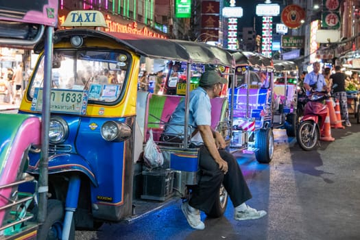 People and Tuk Tuk Taxi at Night Streetmarket on Yaowarat Road in Chinatown in City of Bangkok in Thailand.  Thailand, Bangkok, November, 4, 2024.