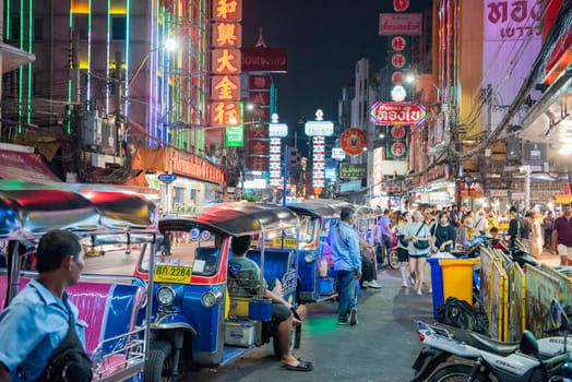 People and Tuk Tuk Taxi at Night Streetmarket on Yaowarat Road in Chinatown in City of Bangkok in Thailand.  Thailand, Bangkok, November, 4, 2024.