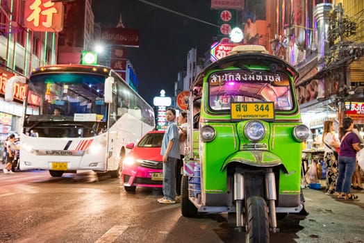 People and Tuk Tuk Taxi at Night Streetmarket on Yaowarat Road in Chinatown in City of Bangkok in Thailand.  Thailand, Bangkok, November, 4, 2024.