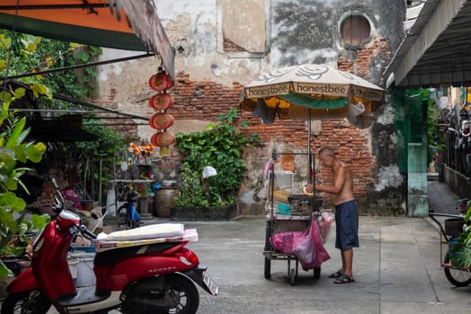 a old men on a grill in alley in Talat Noi at China Town in City of Bangkok in Thailand.  Thailand, Bangkok, November, 5, 2024.
