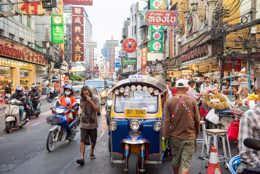 People and Tuk Tuk at Marketstreet on Yaowarat Road in Chinatown in City of Bangkok in Thailand.  Thailand, Bangkok, Dezember, 14, 2024.