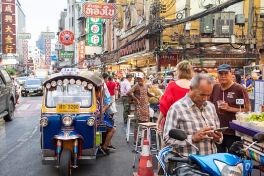 People and Tuk Tuk at Marketstreet on Yaowarat Road in Chinatown in City of Bangkok in Thailand.  Thailand, Bangkok, Dezember, 14, 2024.