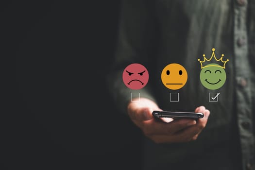 Close-up of customer hand rating service with 5 star feedback icon on smartphone on black background. Online survey, review and satisfaction concept for business success, give five stars good service