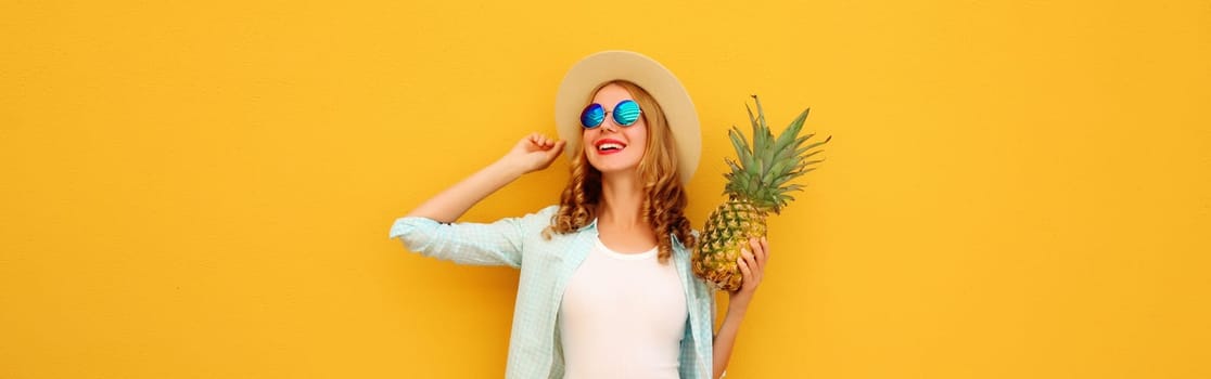 Summer vacation, happy joyful young woman with pineapple fruit in tourist hat, cheerful girl posing on yellow studio background