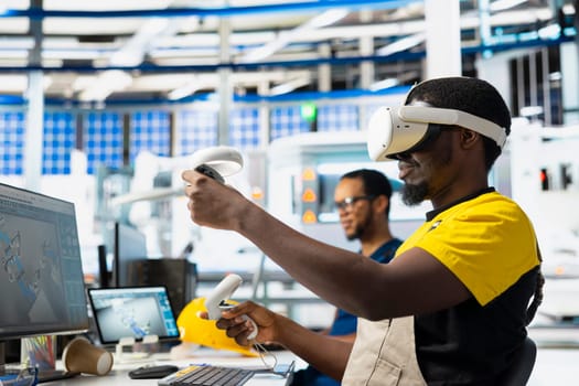 African american engineer in photovoltaics plant uses virtual reality goggles to diagnose malfunctioning systems. Male solar panels factory specialist using VR headset for inspection.