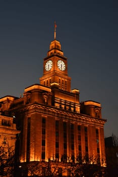 Shanghai, China - 1 April 2025: Historic Customs House building with illuminated clock tower at night on the Bund in central Shanghai