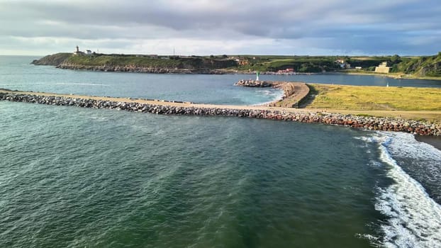 Stunning aerial shot of a scenic coastal harbor showcasing a vibrant jetty alongside charming historical lighthouses