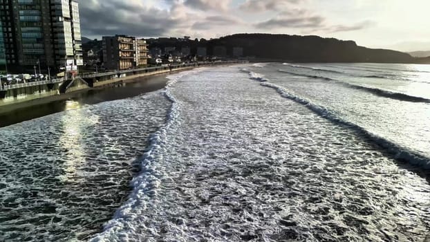 A stunning beach scene showcasing gentle waves lapping against the shore and a tranquil sunset on the horizon