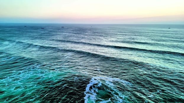 A breathtaking view of the ocean waves in calming colors during sunset, perfect for relaxation visuals.
