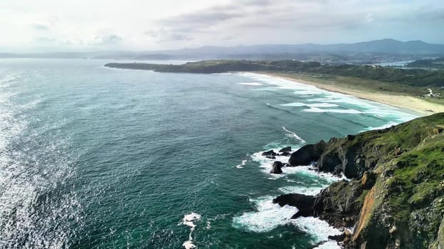Aerial footage showcasing a stunning coastal landscape with majestic cliffs and vibrant ocean waves