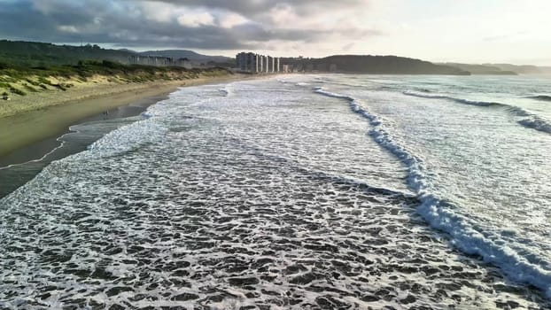 Enjoy a breathtaking view of gentle waves on a serene beach at sunset, ideal for relaxation and peace of mind