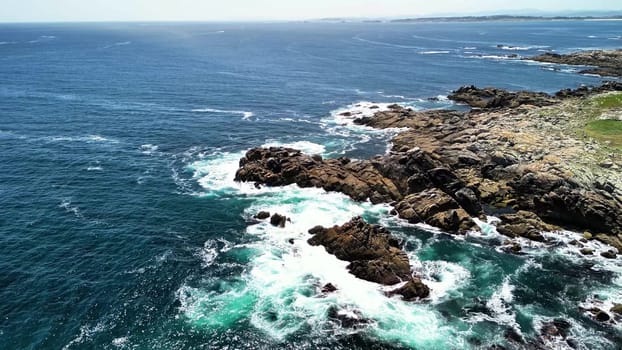 Experience breathtaking aerial views showcasing a stunning rocky coastline with vibrant blue ocean waves crashing
