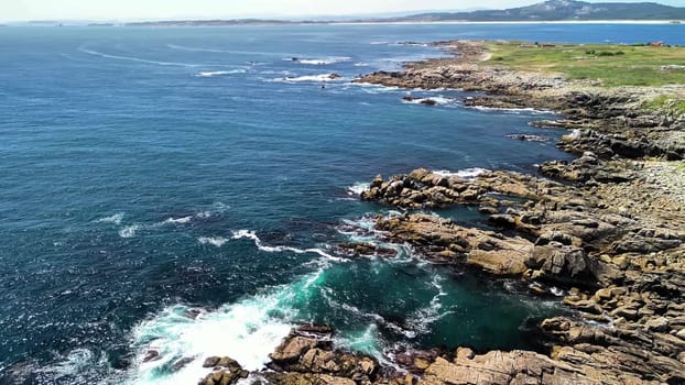 A breathtaking coastal view beautifully showcasing rugged rocks and the vibrant turquoise sea beneath a clear sky