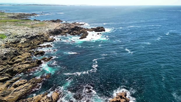 Aerial capture shows the stunning rocky coastline merging with vibrant, crystal clear turquoise waters