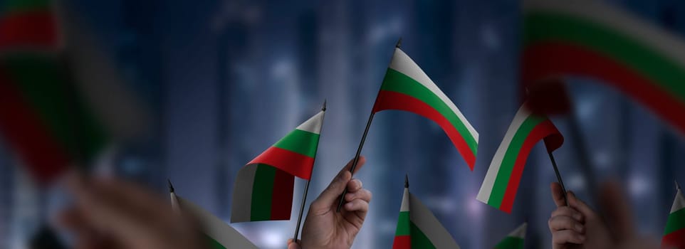 Bulgaria flags in their hands on a blurred urban background. The photo illustration was created without the use of artificial intelligence, only using Photoshop.