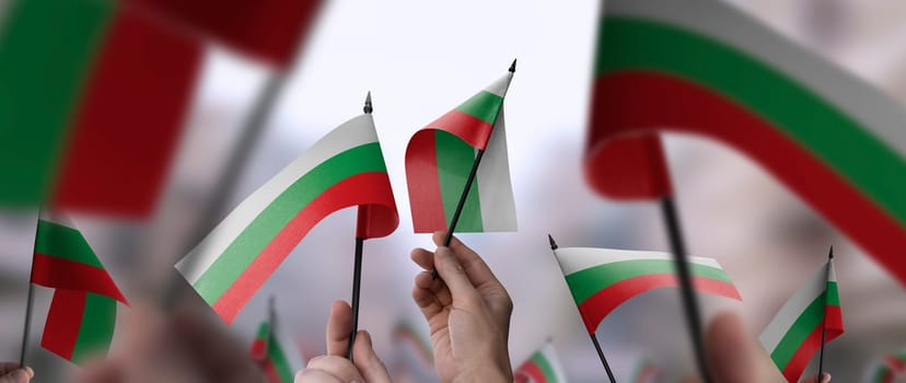 Bulgaria flags in their hands on a blurred urban background. The photo illustration was created without the use of artificial intelligence, only using Photoshop.