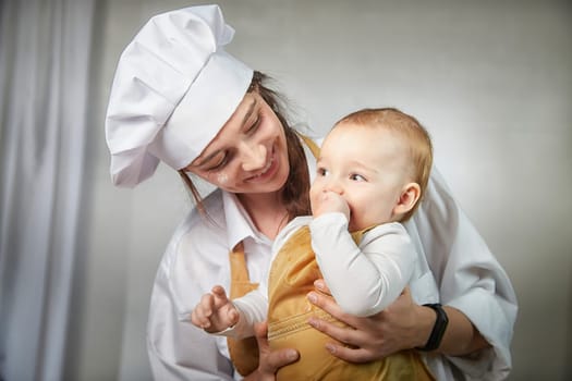 A family enjoys a fun cooking session, playfully covered in flour while engaging with their little ones in warm kitchen. Mother and son having fun
